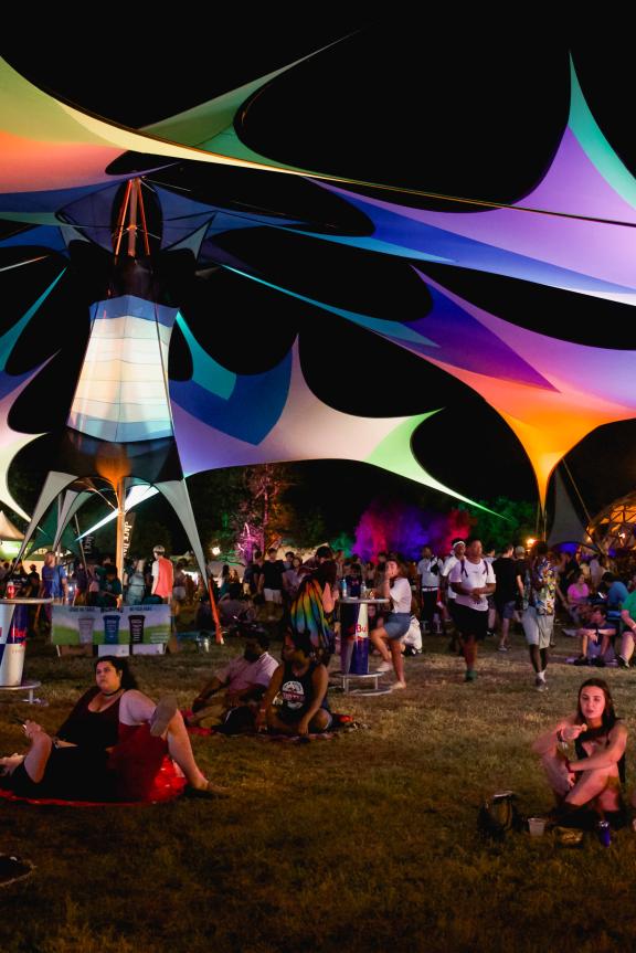 Visitors gathering under colorful shade tents at Mempho Music Festival